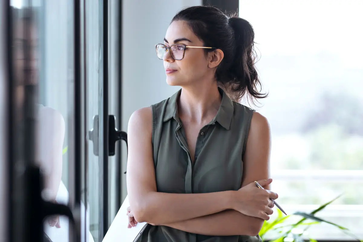Mujer latina profesional contemplando su futuro en Estados Unidos - Coaching cultural Mariposas